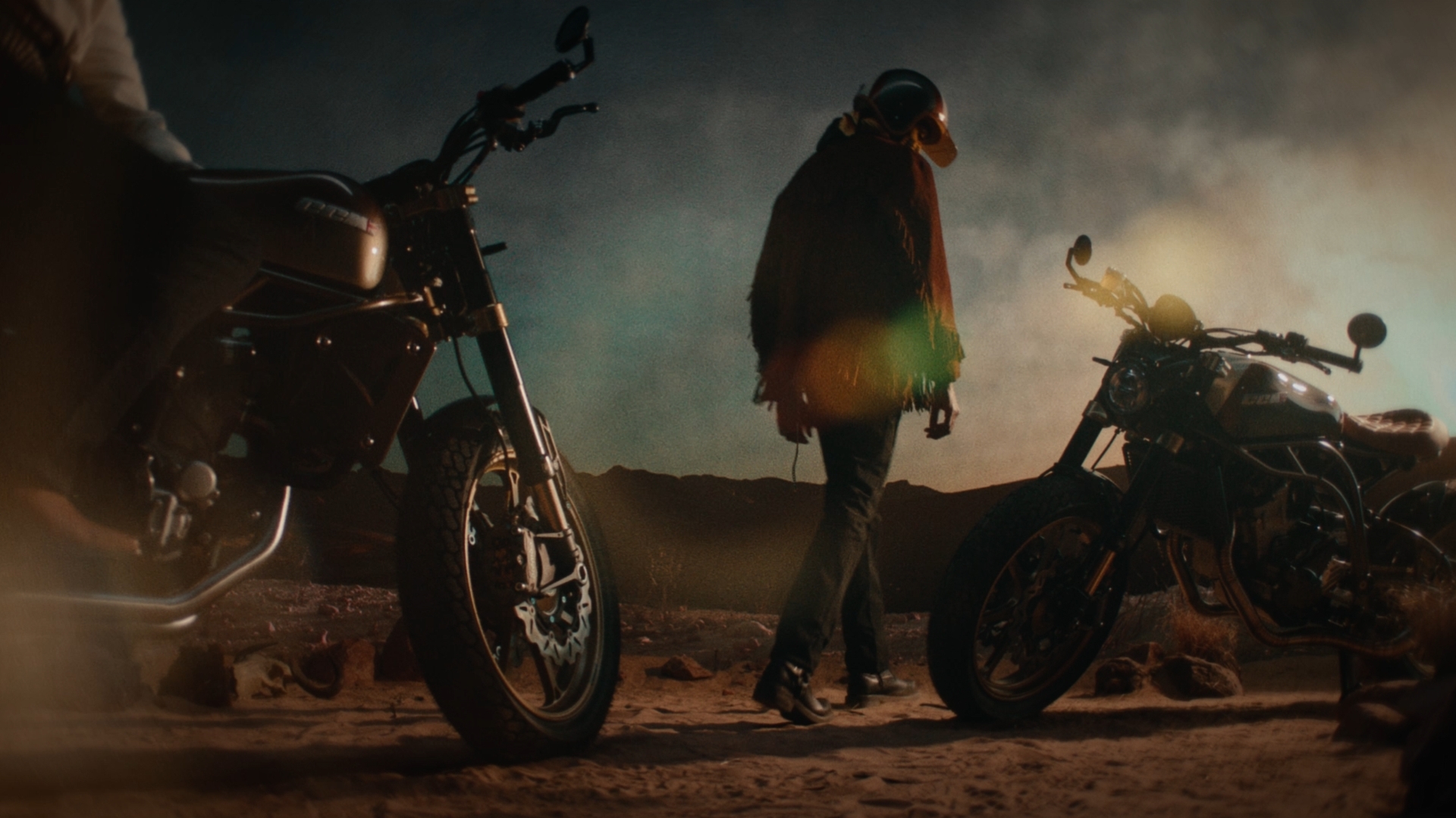 Motorcyclist about to get on his motorbike in a sandy area